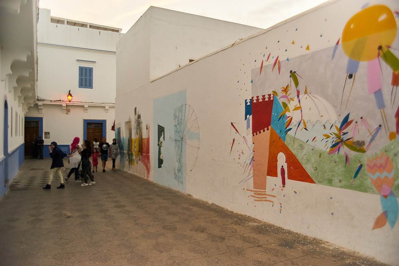 A whitewashed street in Asilah decorated with murals
