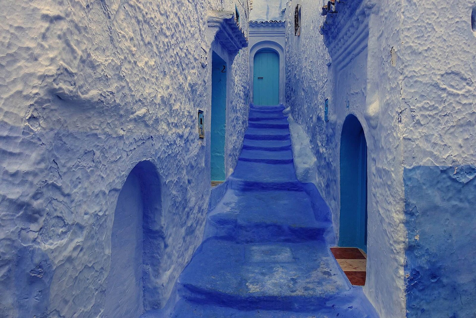 Blue-washed steps and doorways in a lane in Chefchaouen