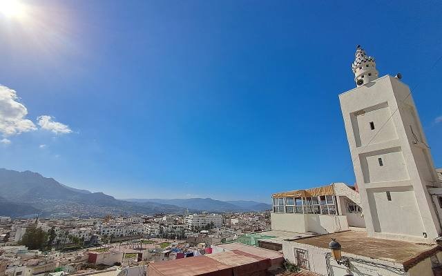 The white houses of Tetouan spreading over the hillside below the Rif mountains, seen from the old medina